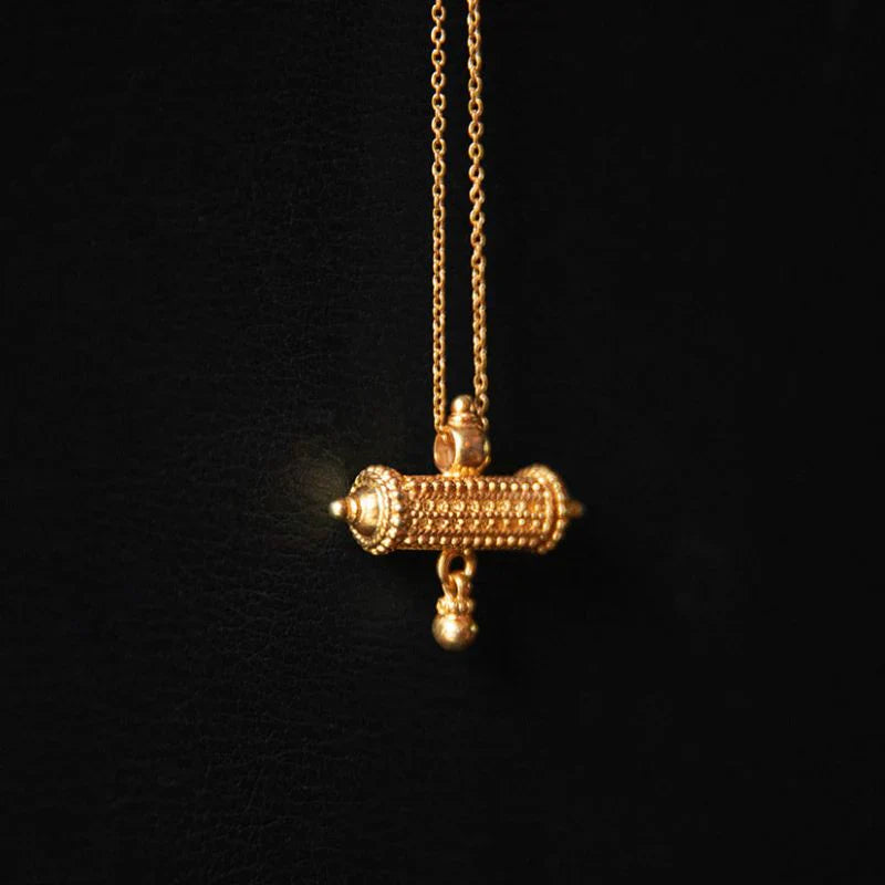 22K gold vermeil over 925 sterling silver barrel amulet charm necklace with beaded detail and bell, worn as a protective symbolic object on a fine chain.