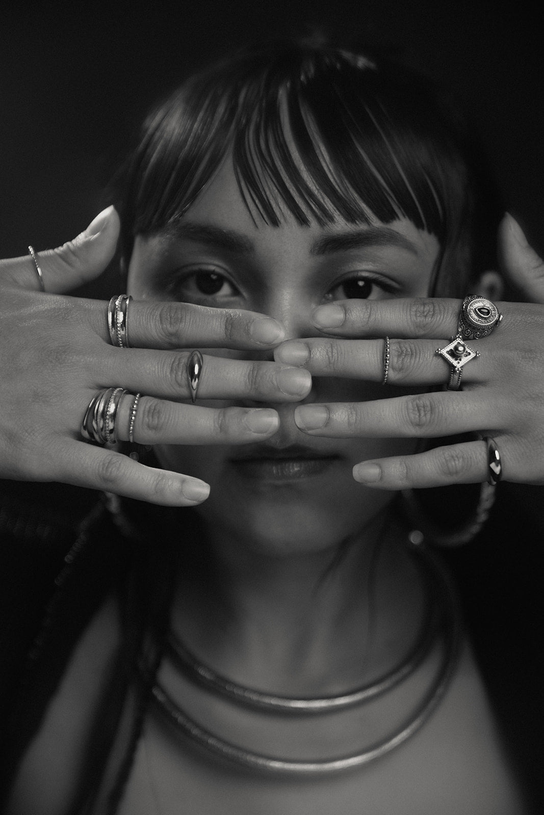 Silver stacking rings with an eye motif and gemstone details on both hands 