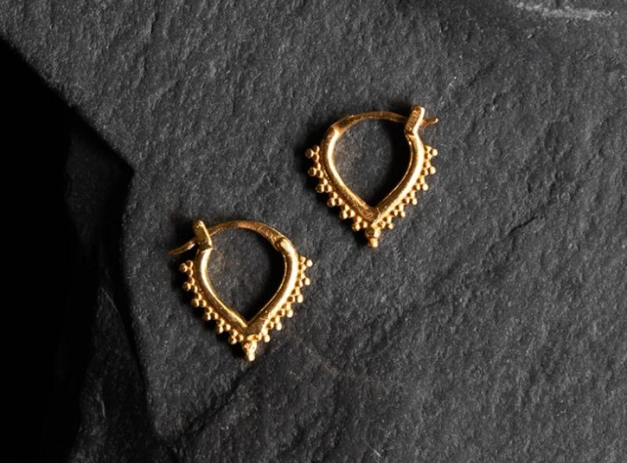 Woman wearing gold vermeil rings showing how long gold vermeil lasts on skin by Noir KĀLA.
